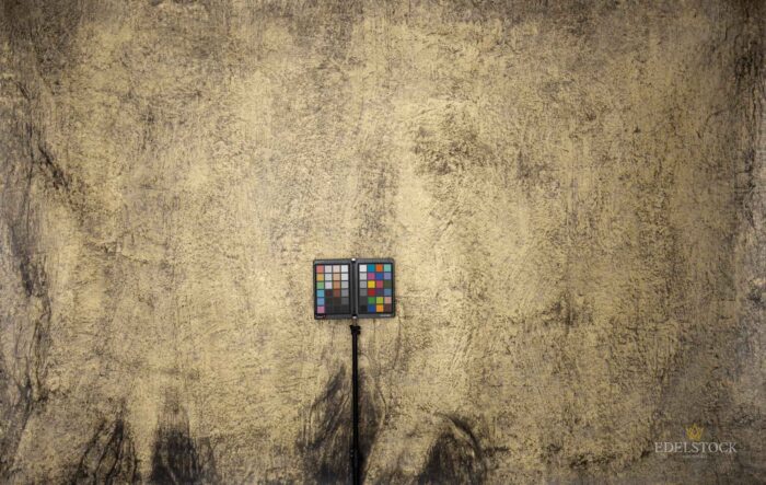 Gold / Graues XXL Wandbild im Grossformat mit feinen Verläufen und Spachtelstruktur in Dunkelgrau in einem gut beleuchtetem Ausstellungsraum